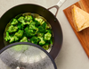 Steaming broccoli in the Misen Pre-Seasoned Carbon Steel Wok with a glass lid.