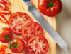 Slicing beef steak tomatoes with a blue, eight inch Misen Serrated Knife