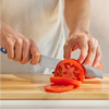 Using a blue, Misen, five inch, short serrated knife to cut a tomato