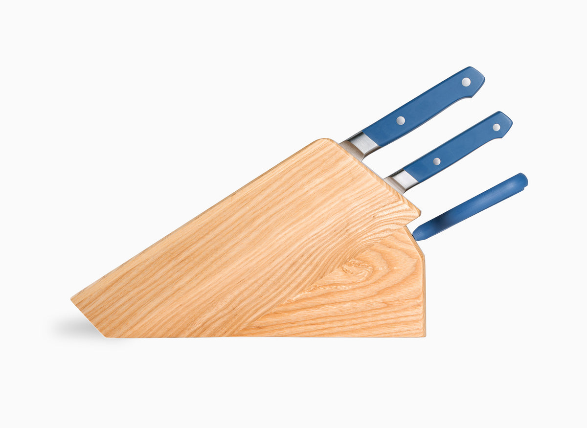 An Ash Misen Knife Block seen from the side, containing a 5-piece Blue Misen Essentials Knife Set.