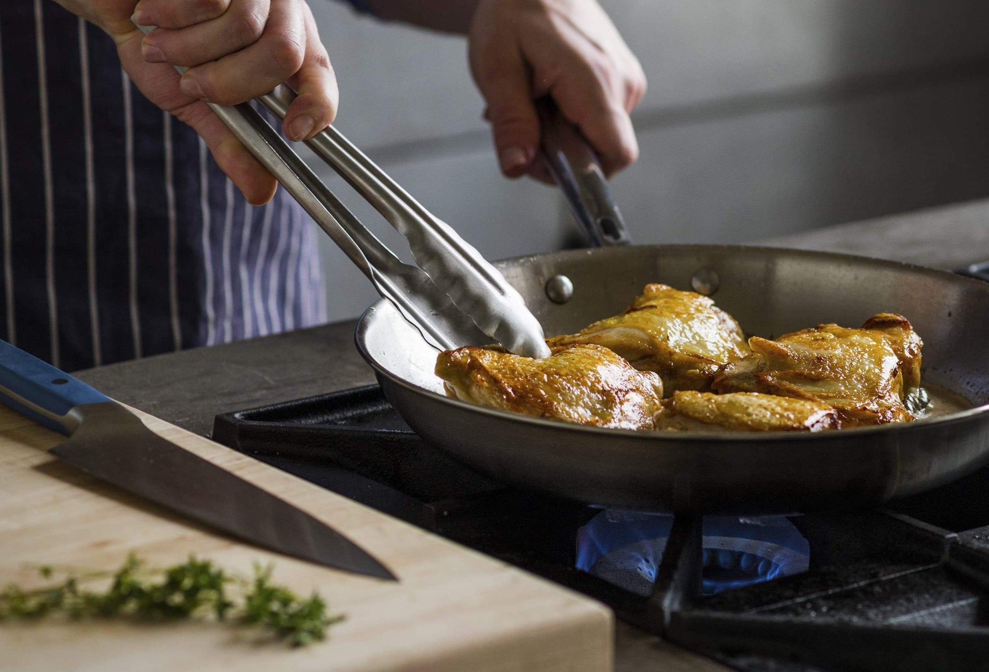 Skillet pan: A chef prepares chicken thighs in a stainless steel skillet