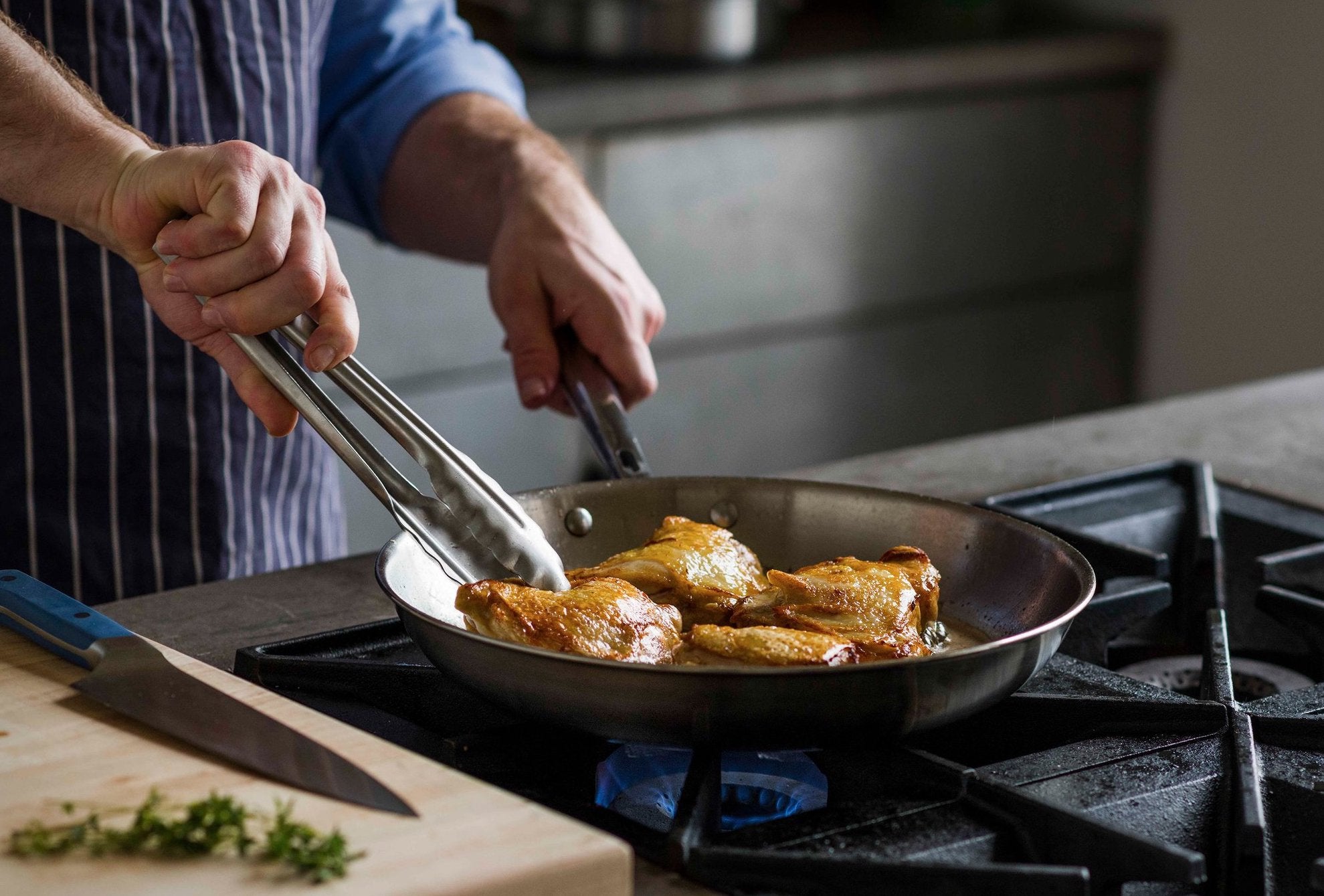 Skillet cooking: A home cook browns chicken thighs in a skillet