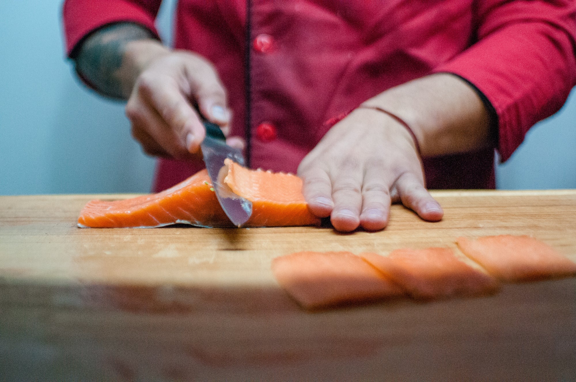 Full tang knife: A man slices salmon