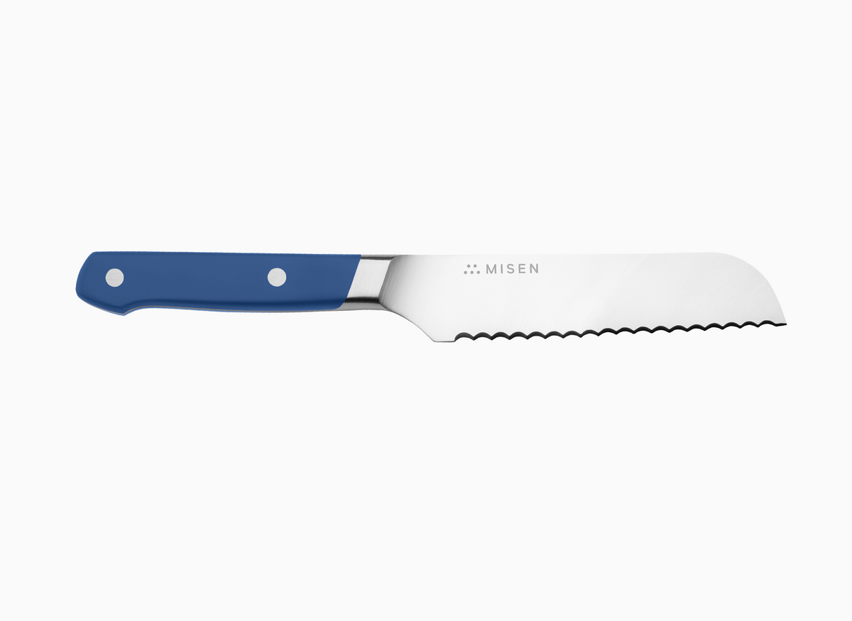 A side view of a blue Misen Short Serrated Knife on a white background.