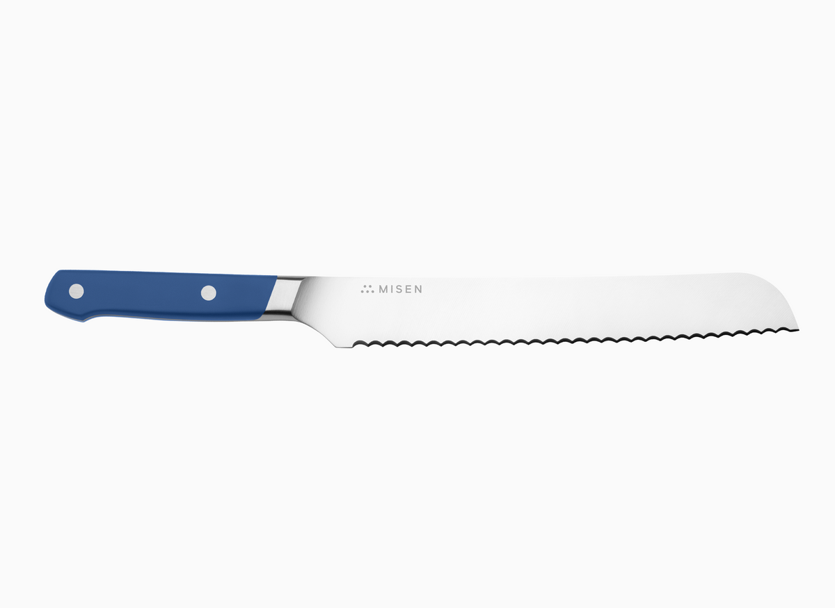 A side view of a blue Misen Serrated Knife on a white background.