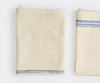 Two folded Misen Kitchen Towels lie flat and next to each other on a white background, with the varying blue stripe patterns visible.