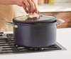 A chef places a lid atop a Misen Nonstick Stock Pot on a stovetop.