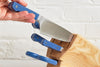 A hand easily retrieves a Misen Chef’s Knife from a full Ash Misen Knife block.