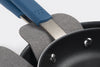 Close up of stacked nonstick pan handles, with a grey felt pan protector between the upper and lower pans.
