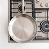 A Misen Stainless Steel Skillet atop a gas stove top.