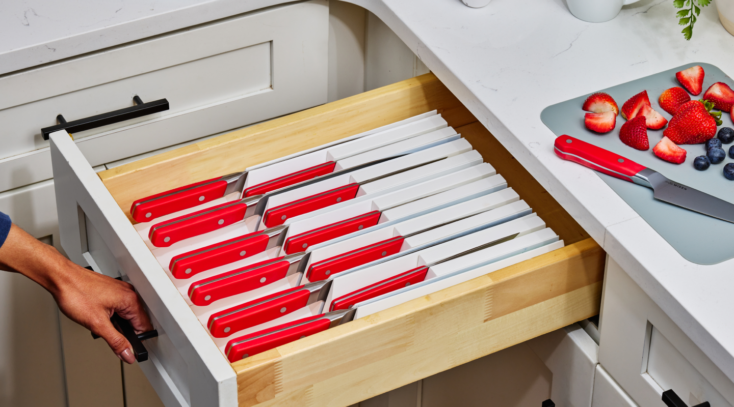 Miser red-handled steak knives organized in kitchen drawer with individual blade guards