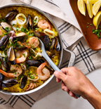 Seafood paella with mussels, shrimp, and squid in a stainless steel pan