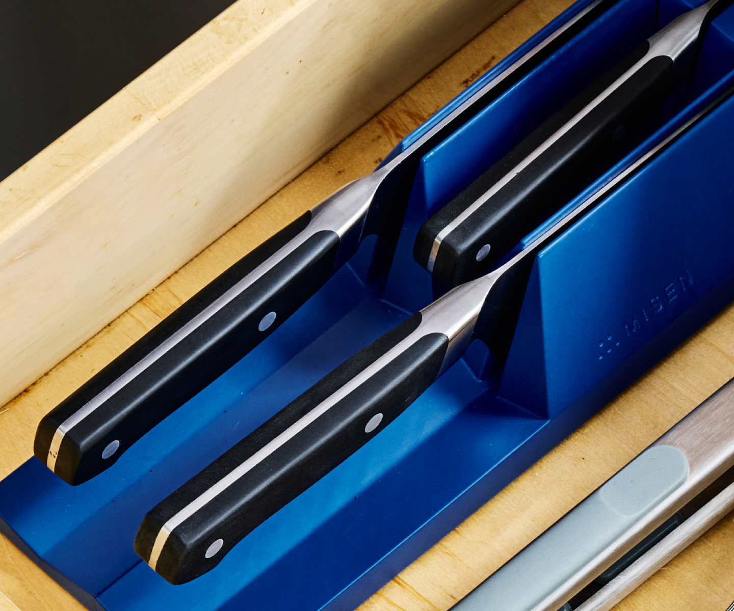 Misen kitchen knives stored in blue drawer knife organizer inside wooden drawer