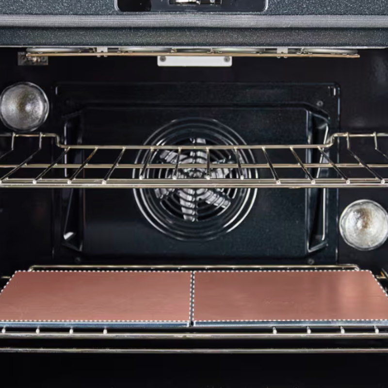 Convection oven interior with fan, wire rack, and copper non-stick oven liners on bottom rack