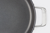 A bird’s eye view of part the Misen Nonstick Rondeau, with one handle and rounded edge visible, on a white background.