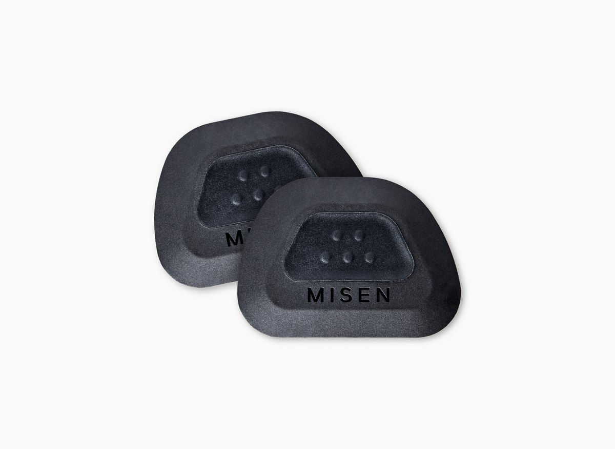 Two black Pan Scrapers with a raised Misen logo of five dots (two on the top, three on the bottom) and engraved with the word Misen.