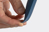 A hand pressing and bending the edge of a blue Misen Spoontula against its forefinger.