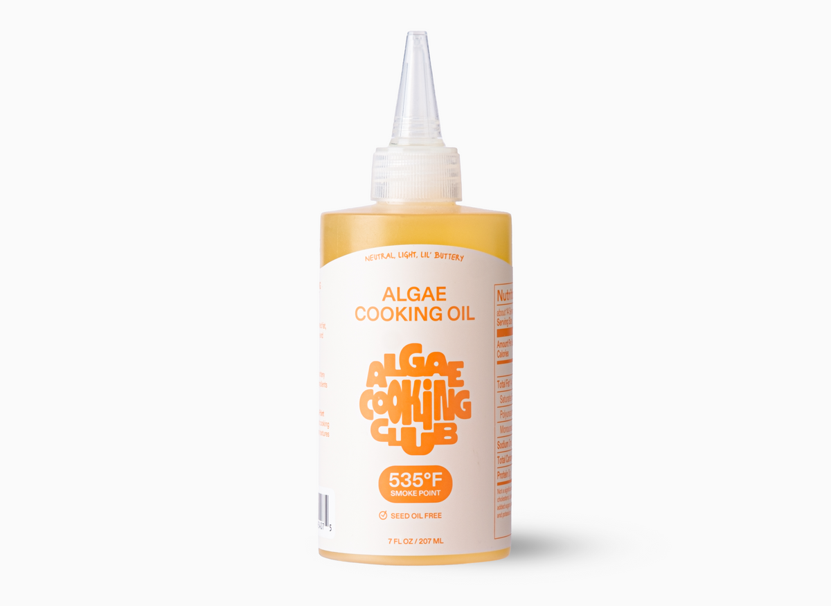 A bottle of Algae Cooking Oil with a yellow label that reads "NEUTRAL, LIGHT, LIL' BUTTERY ALGAE COOKING OIL 535°F SMOKE POINT SEED OIL FREE 7 FL OZ / 207 ML".