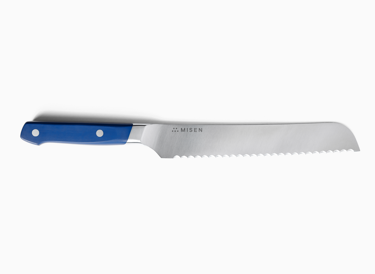A top-down view of a blue-handled 8 inch Serrated Knife 2.0 against a white background. The knife is positioned horizontally with the handle on the left and the serrated blade extending to the right. The ACUTO440 steel blade is silver-toned and features the "MISEN" logo and name. The handle is a rich blue with two silver rivets visible.