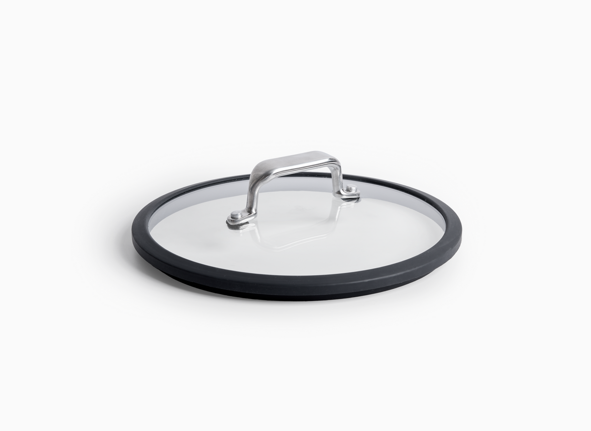 A round 8 inch Misen Glass Lid with a dark gray silicone rim and a silver metal handle.