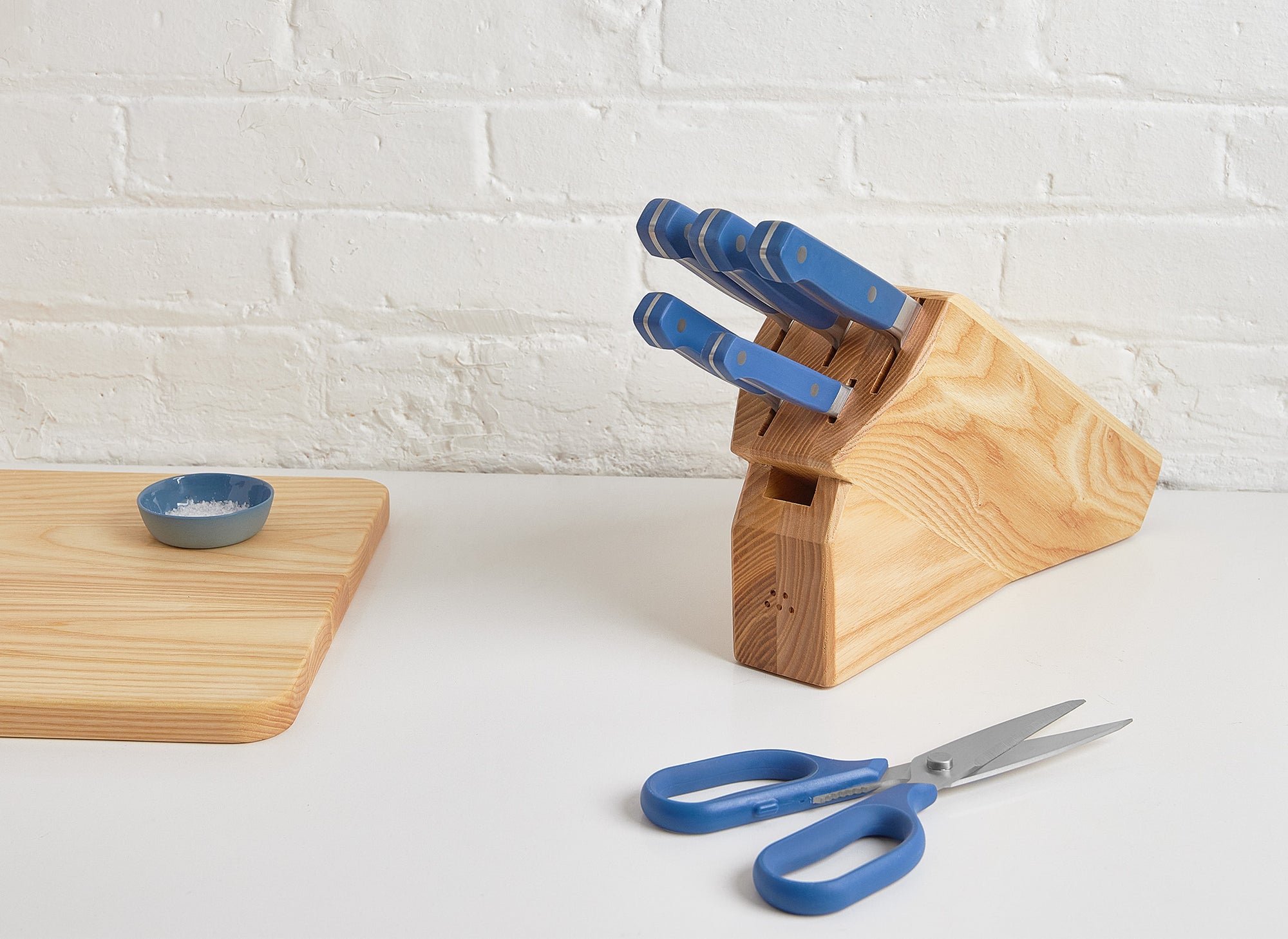 An Ash Misen Knife Block containing a 5-piece Misen Knife Set, with Misen Kitchen Shears nearby on a white countertop.