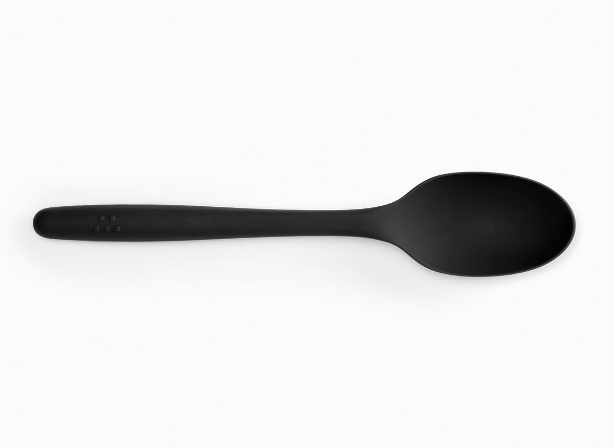 A black silicone mixing spoon on a white background.