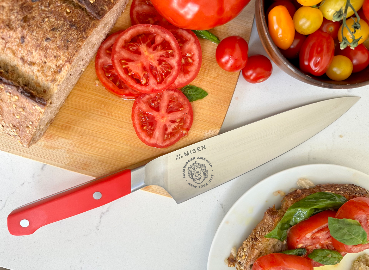 Using the Misen x George Motz - Hamburger America 8 inch Chef's Knife to slice tomatoes for a sandwich.