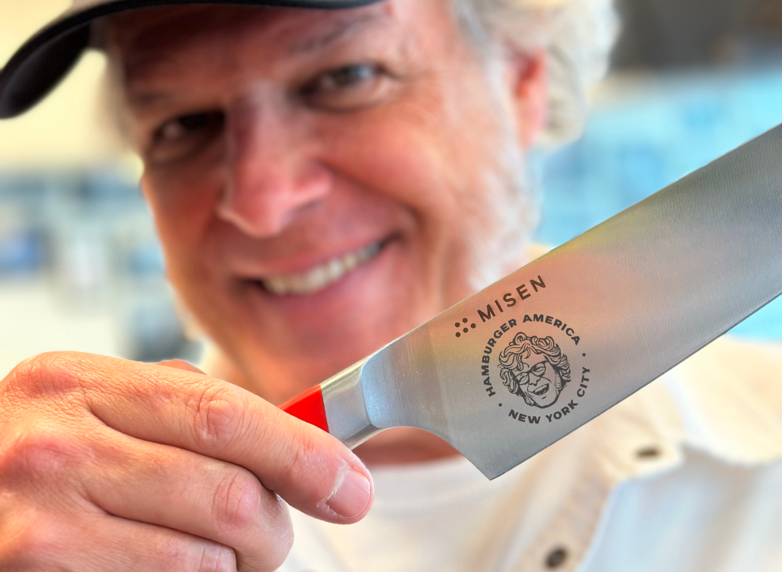 George Motz holding the Misen x George Motz - Hamburger America 8 inch Chef's Knife.