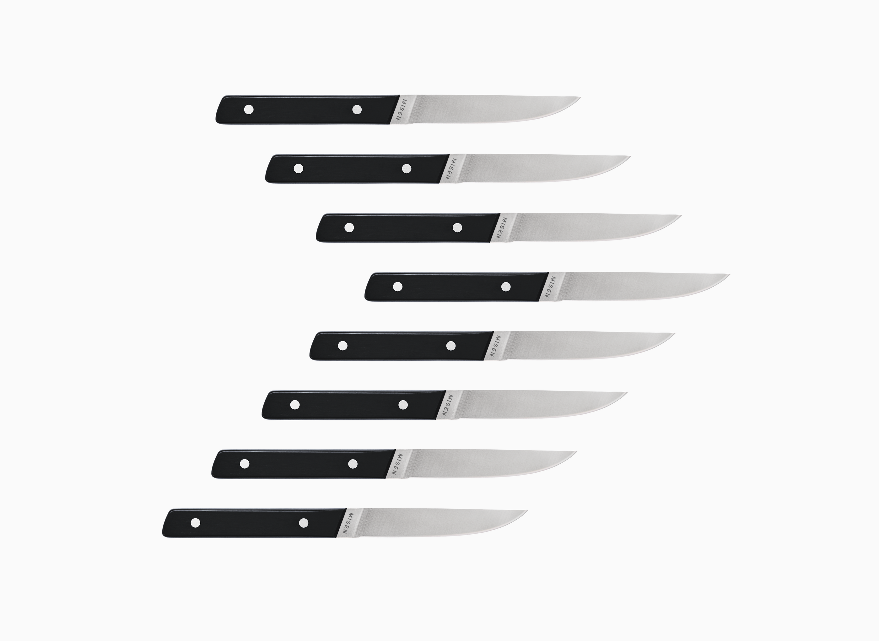 Set of eight straight edge Misen ACUTO steak knives with black handles on a white background