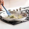 Sauteéing onions and basil in a Misen Stainless Steel Pan with a blue Misen Mixing Spatula