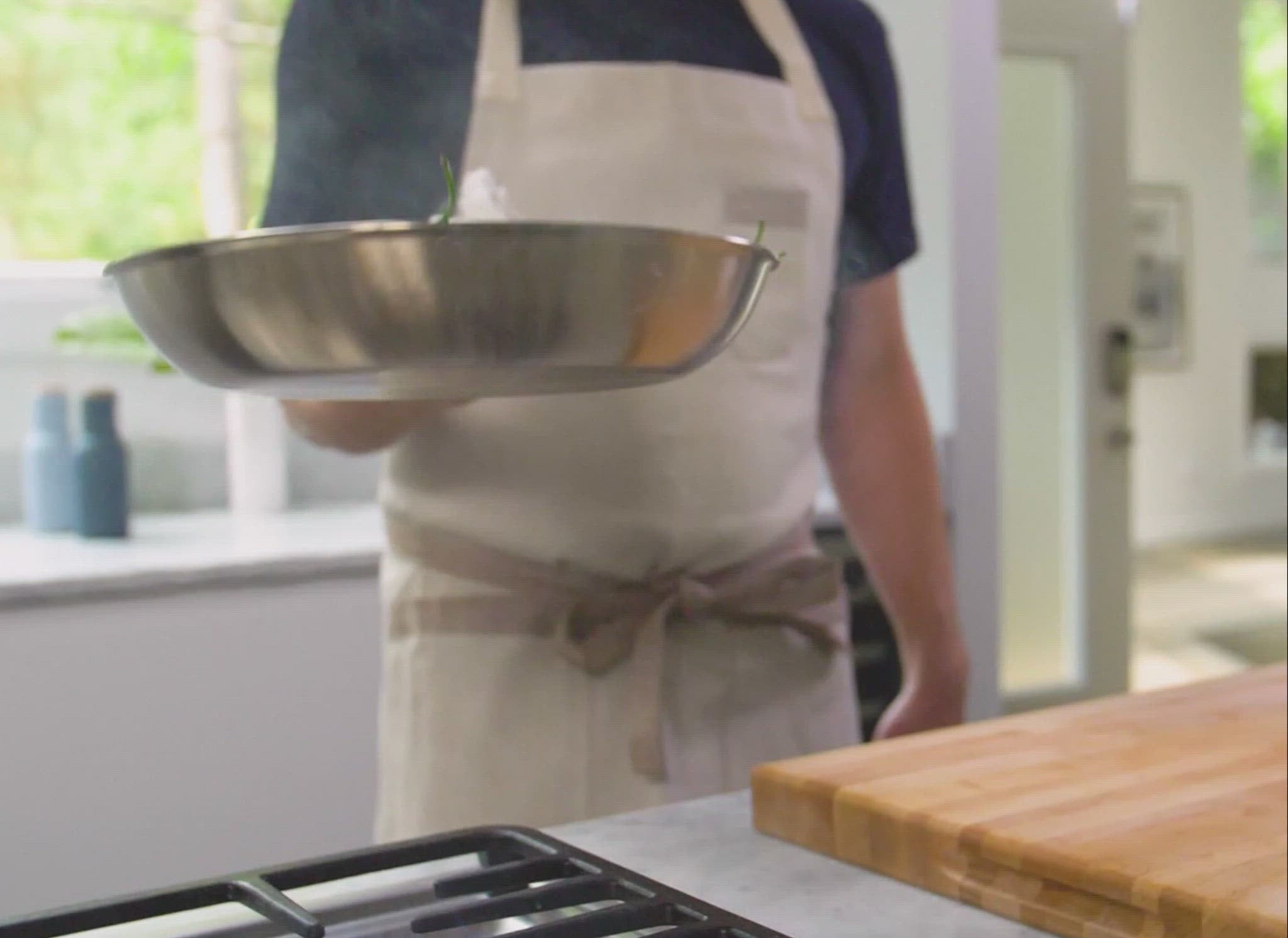 A video of a chef using a Misen Stainless Steel Pan to toss shishito peppers over a stovetop.