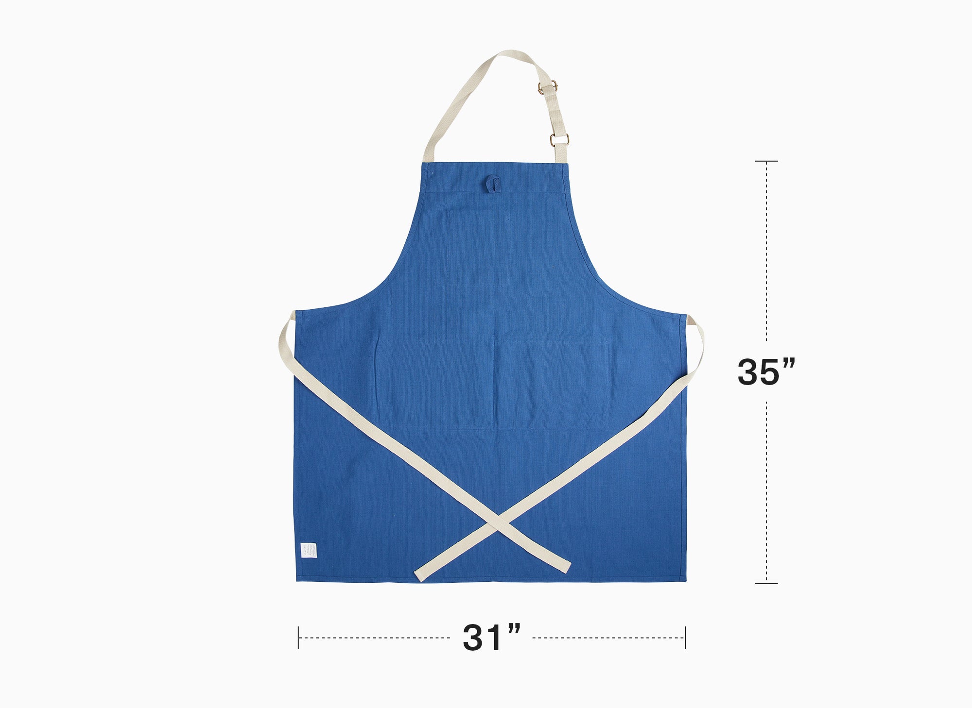A blue Misen Apron lies flat on a white background. Graphics on the image show the apron’s measurement: 35 inches tall and 31 inches wide.