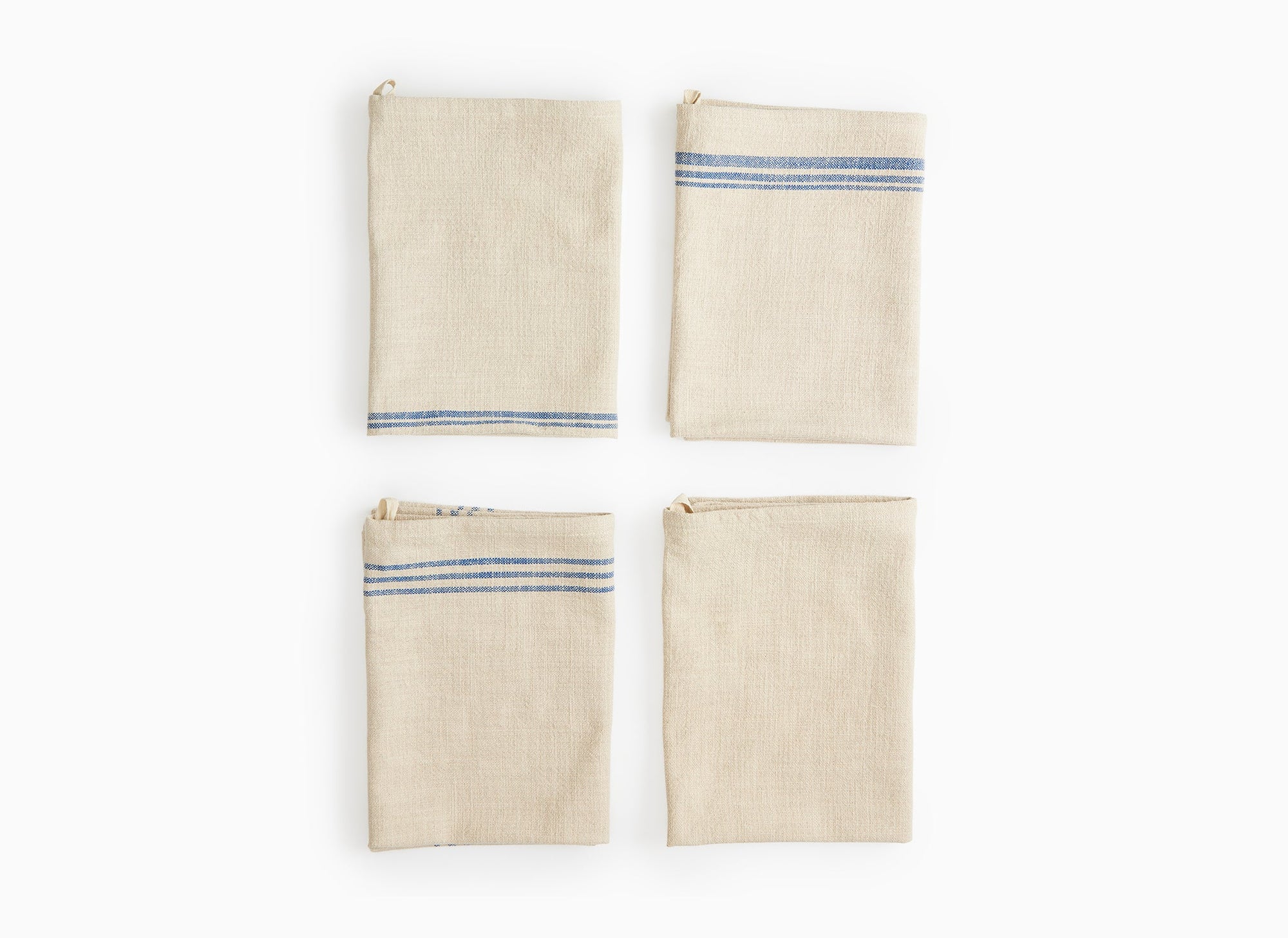 Four folded Misen Kitchen Towels lie flat on a white background, stacked two-by-two. The varying blue stripe patterns are visible on the towels.