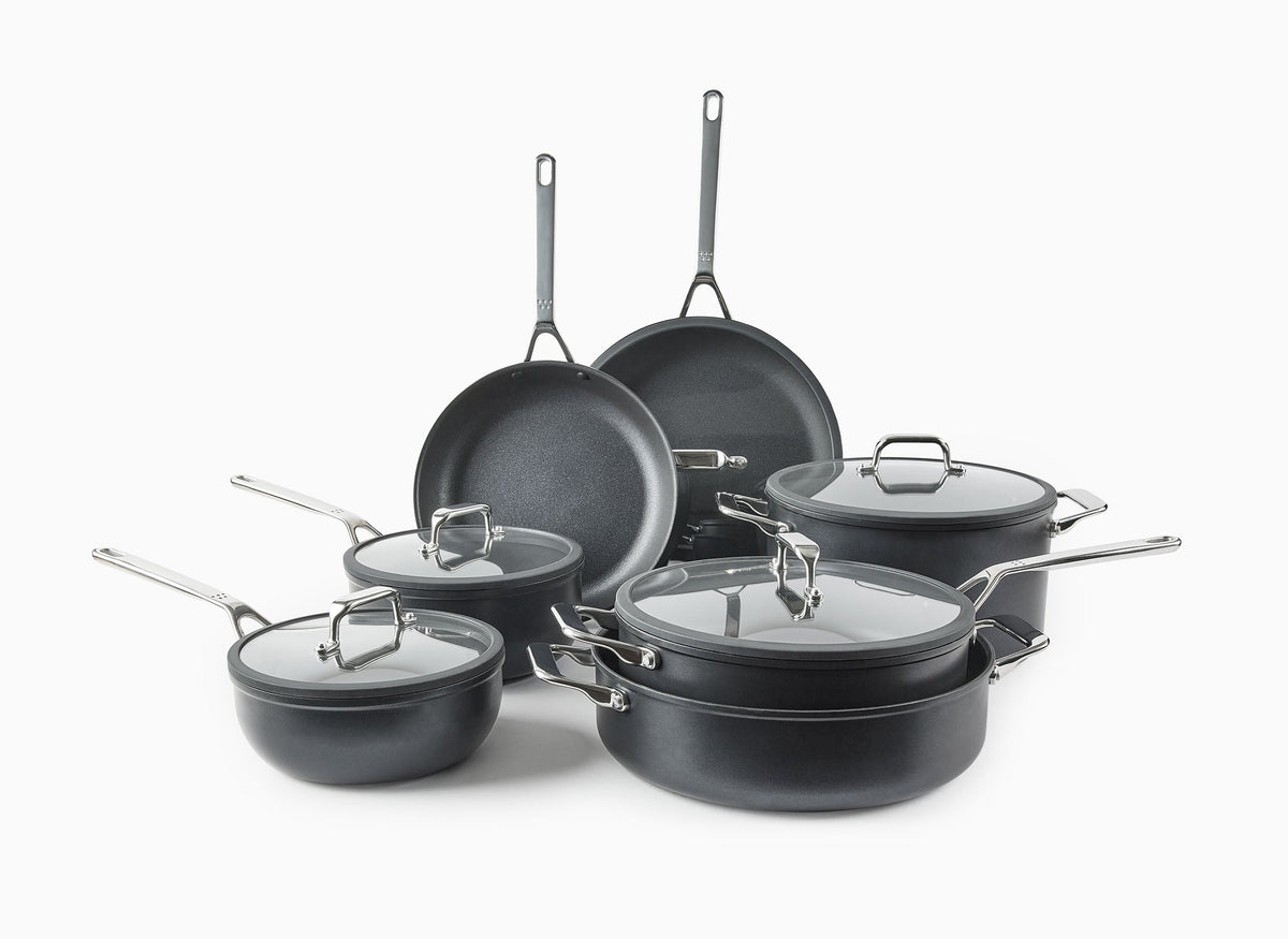 The Misen 12-Piece Essentials Cookware Set on a white background, with most pieces visible: the 10- and 12-inch Nonstick Pans, Nonstick Rondeau, Nonstick Stock Pot, Nonstick Sauté, and 2QT and 3QT Nonstick Saucier, with lids.