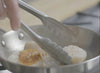 A video of scallops being flipped by tongs in a Misen Stainless Steel Pan.